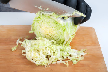 To cut a young cabbage cook food fresh vegetables. To prepare the salad or soup