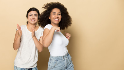 Joyful diverse multicultural female friends dancing together.