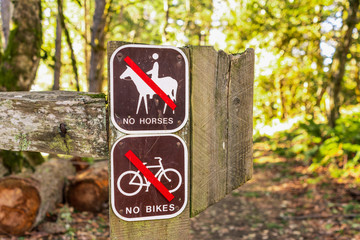 Signs posted at the entrance on one of the hiking trails, warning that it is closed to bikes and horses, Purisima Creek Redwoods Preserve, Santa Cruz mountains, California