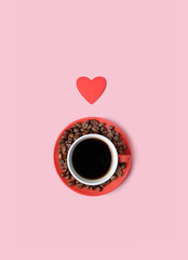red cup of black coffee, coffee beans and heart on pink background. Romantic minimal composition, Valentine's day concept. copy space. flat lay. template for design