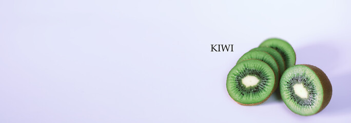 A kiwi fruit is sliced on a white background