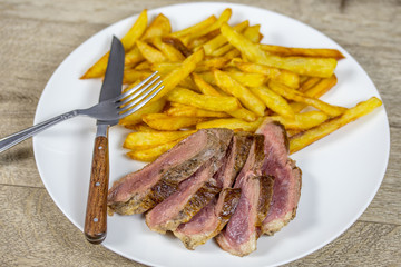 magret de canard et frites dans une assiette