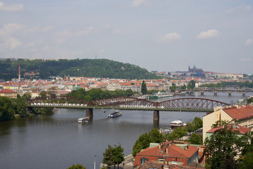 Fototapeta na wymiar Top view of the wide Vltava river. Horizontal photo of colorful European city of Prague in Czech Republic daytime, cloudy sky, month of may, travel in tourist place.