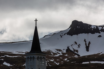 Church tower with cross in Arctic environment in winter