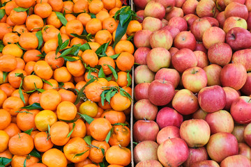 Tangerines and apples for sale at a market