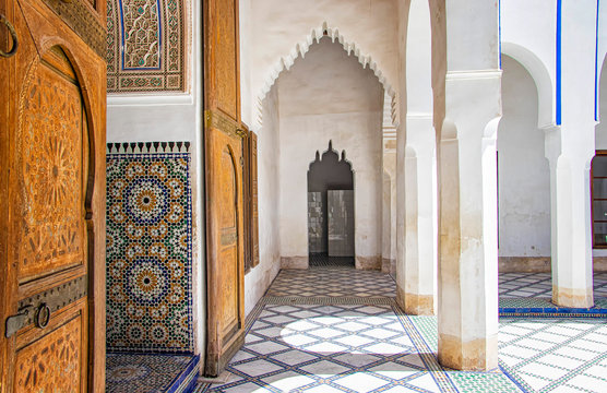 Detail of islamic building. It is an old architecture in the middle of the Moroccan city. There are white walls with wooden carved characters. There is summer time.