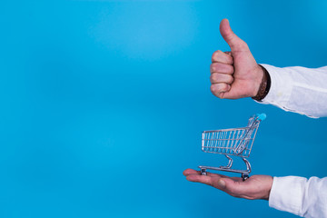 hand with miniature supermarket cart