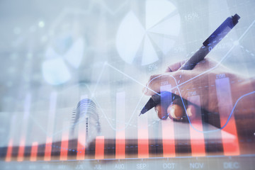 Forex graph on hand taking notes background. Concept of research. Multi exposure