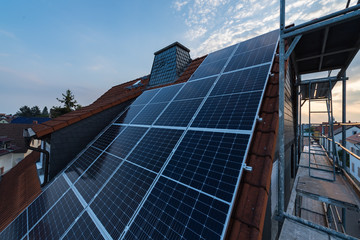 Solar-Panels auf Hausdach mit Gerüst am linken Rand