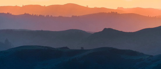 Sunset view of hills and valleys, each layer colored differently;  Santa Cruz mountains ; San Francisco bay area, California