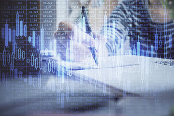 Financial forex graph drawn over hands taking notes background. Concept of research. Double exposure