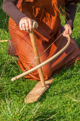 Women trying to make a fire with with a bow drill