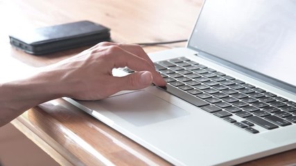 Male hand is typing on laptop, presses space bar. Man works in program. Closeup