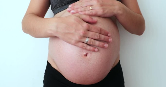 Pregnant woman caressing her 9 month belly
