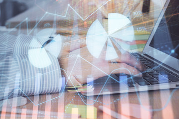 Multi exposure of stock market graph with man working on laptop on background. Concept of financial...