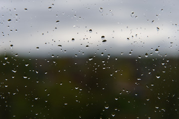 Raindrops on a window pane. Autumn and fall concept.