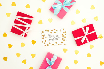 Obraz premium Valentines day composition with paper card, gifts and golden confetti on white background. Flat lay