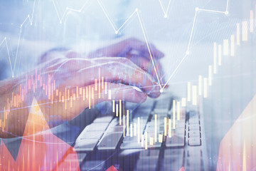Multi exposure of graph with man typing on computer in office on background. Concept of hard work. Closeup.