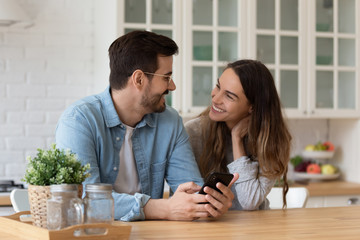 Smiling young man showing funny videos to mixed race woman.