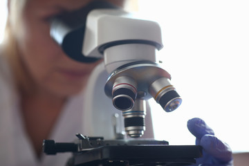 Woman look microscope on the background laboratory is a study human biology analyzes for non-compliance with the requirements organization public health at international level