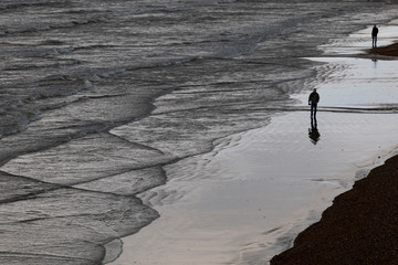 man walking on monotone beach in Brighton