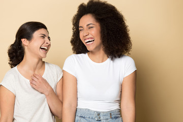 Overjoyed indian and african american ethnic young girls laughing.