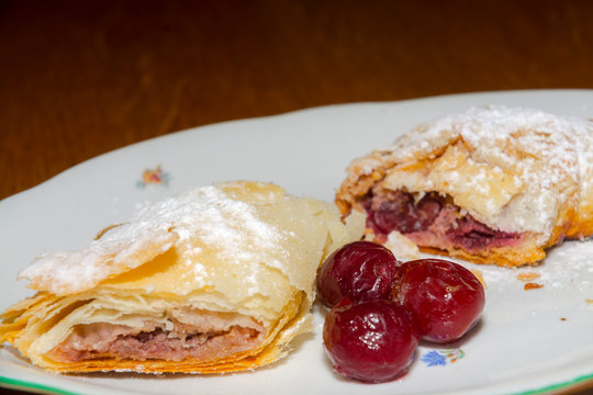 Plate Of Sour Cherry Strudel On A Wooden Table