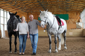 People on a horse training in a wooden arena