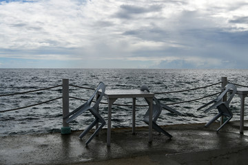 sea ​​view before the rain with white chairs and a table