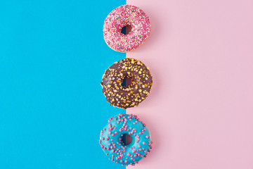 Donuts on a pastel pink and blue background. Minimalism creative food composition. Flat lay style
