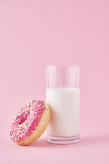 Donuts with glass of milk on a pink background