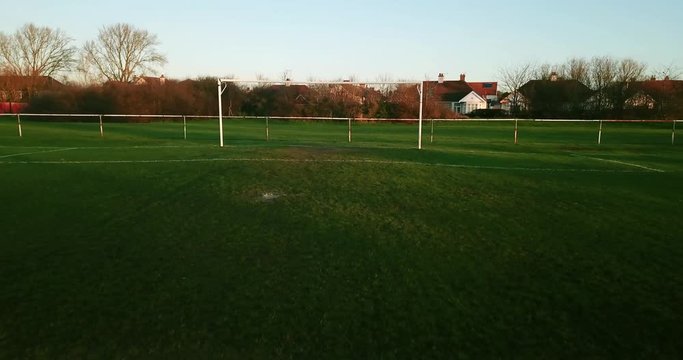 Flying Low Shot Out Underneath Football Soccer Goal Across The Pitch Revealing Winter Muddy Green Grass Blue Sky Fourk Uk Football Pitch Wet Grass