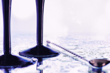 Background with tall glasses for sparkling wines. Champagne and spray in glass glasses. Celebratory drink with reflection.