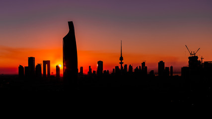 Fototapeta na wymiar Dark Silhouettes of skyscrapers and buildings - Sunset in Kuwait City - Magenta 