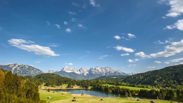 timelapse of moving clouds on blue sky over mountain range in Bavaria