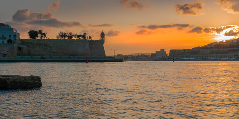 Obraz premium Valletta seafront skyline view seen from Birgu shoreline at dusk, Malta