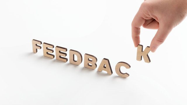 Woman creating Word feedback of wooden letters on white