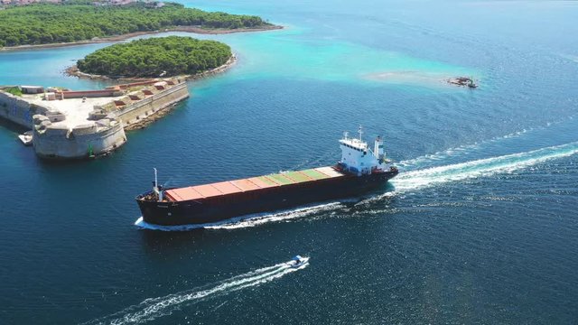 St. Nicholas fortress at Sibenik bay entrance and freight ship passing by, archipelago od Dalmatia, Croatia, drone footage