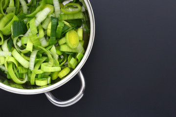 Washed sliced leek in a steel pan, ready to cook for dinner. Copy space text.
