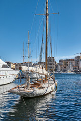 Fototapeta premium Single Sailboat at Dock with Calm Water Reflections