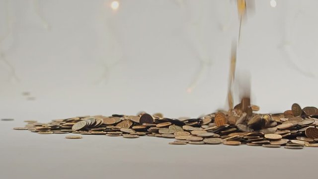 White-gloved hands scooping up a pile of gold coins. They sort out and scatter money.On white background. Garland. Money glitters.