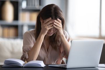 Stressed woman suffer from headache at workplace