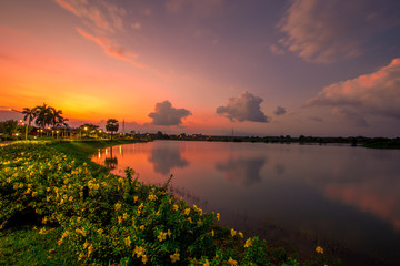 The blurred abstract background of the colorful twilight evening sky near the large lake, with cool breezes while sitting or exercising in the park.