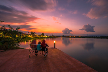 The blurred abstract background of the colorful twilight evening sky near the large lake, with cool breezes while sitting or exercising in the park.