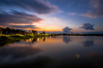 Fototapeta premium The blurred abstract background of the colorful twilight evening sky near the large lake, with cool breezes while sitting or exercising in the park.