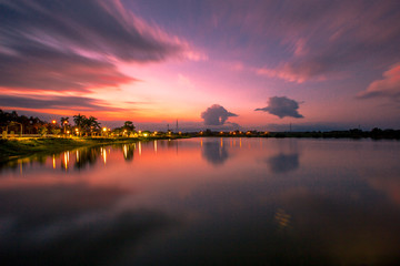 The blurred abstract background of the colorful twilight evening sky near the large lake, with cool breezes while sitting or exercising in the park.