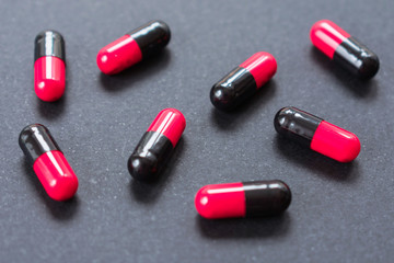 Capsules of red and black on a black background.Close-up.