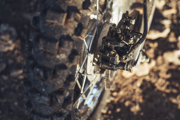 Close-up of disc rear brakes of off-road motorcycle enduro, dirty wheel
