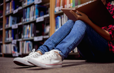 College student reading book at library university.  Education concept.