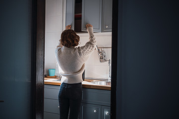 Young woman preparing breakfast in the kitchen on a sunny morning